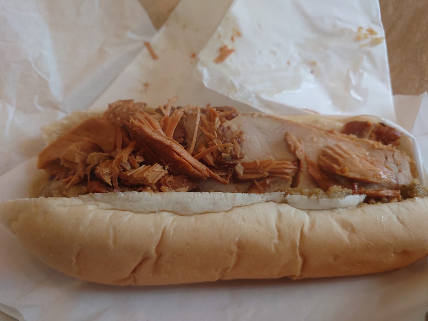 A baguette filled with pulled meat