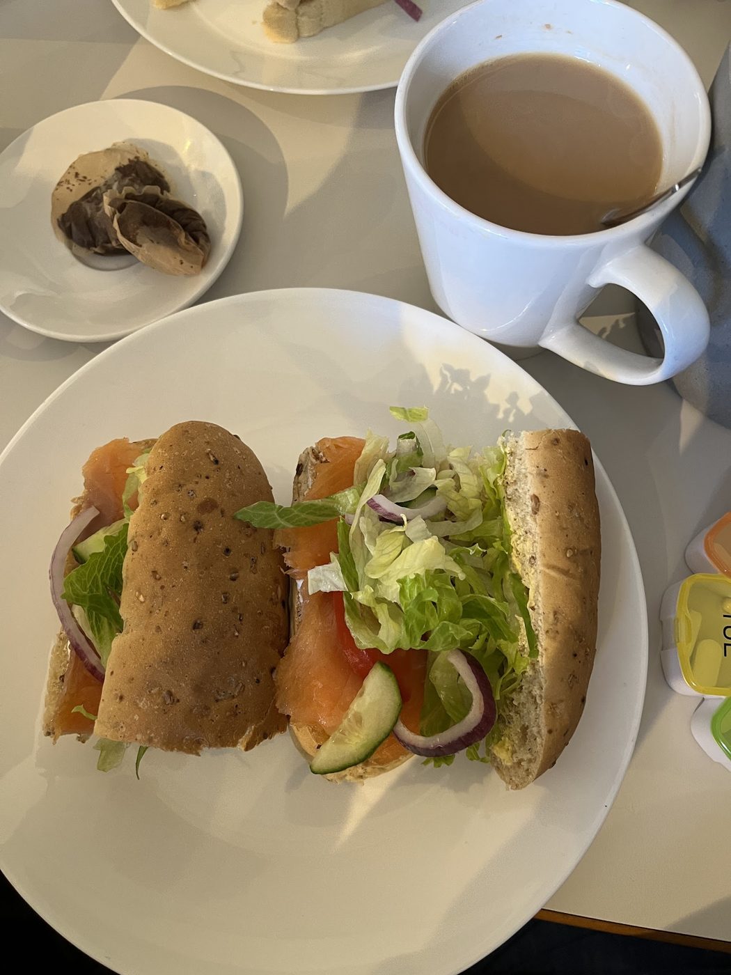 A sandwich with salad beside a mug of tea